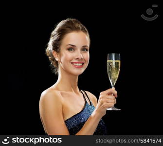 party, drinks, holidays, luxury and celebration concept - smiling woman in evening dress with glass of sparkling wine over black background