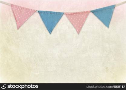 Party flags hanging on colored cement wall background, decorate items for festival, celebrate event