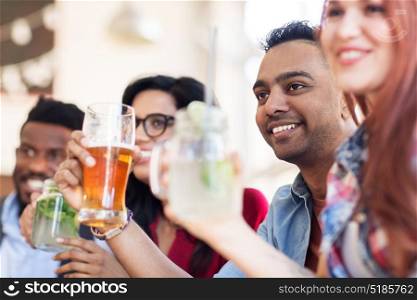 party, holidays and people concept - group of happy international friends with drinks at restaurant. happy friends with drinks at restaurant
