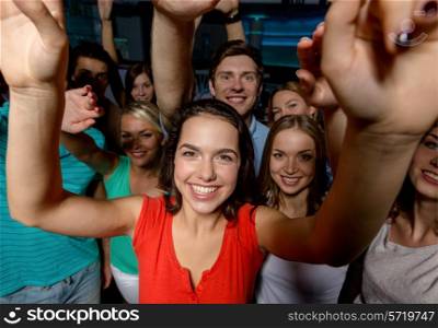 party, holidays, celebration, friends and people concept - smiling friends dancing and waving hands in club