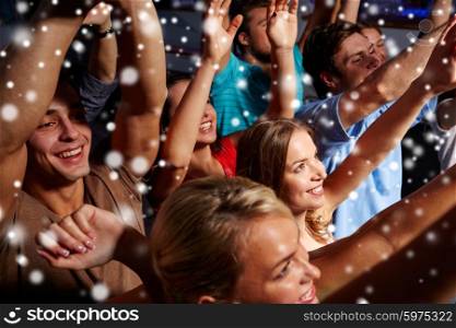 party, holidays, celebration, nightlife and people concept - group of smiling friends waving hands at concert in club and snow effect