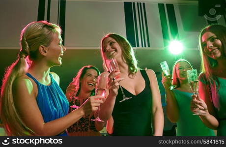 party, holidays, celebration, nightlife and people concept - happy young women with glasses of champagne in club