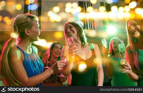 party, holidays, celebration, nightlife and people concept - happy young women with glasses of champagne in club