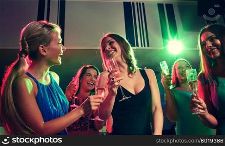 party, holidays, celebration, nightlife and people concept - happy young women with glasses of champagne in club