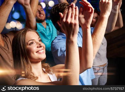 party, holidays, celebration, nightlife and people concept - smiling friends applauding at concert in club