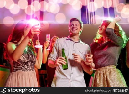 party, holidays, celebration, nightlife and people concept - smiling friends clinking glasses of champagne and beer in club