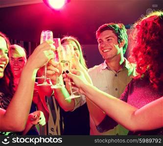 party, holidays, celebration, nightlife and people concept - smiling friends clinking glasses of champagne in club