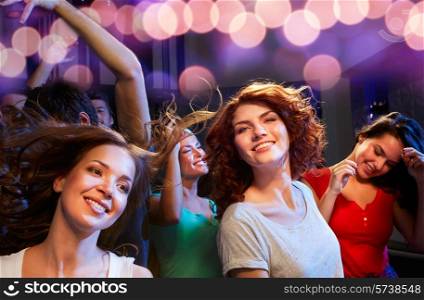 party, holidays, celebration, nightlife and people concept - smiling friends dancing at concert in club