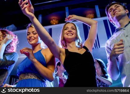 party, holidays, celebration, nightlife and people concept - smiling friends dancing in club