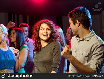 party, holidays, celebration, nightlife and people concept - smiling friends dancing in club