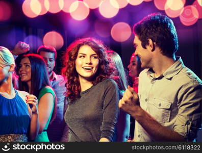 party, holidays, celebration, nightlife and people concept - smiling friends dancing in club