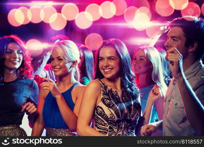 party, holidays, celebration, nightlife and people concept - smiling friends dancing in club