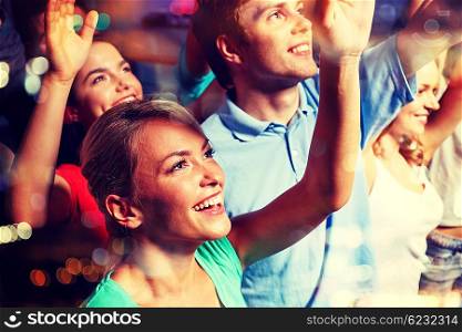 party, holidays, celebration, nightlife and people concept - smiling friends waving hands at concert in club
