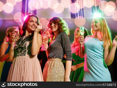 party, holidays, celebration, nightlife and people concept - smiling friends with glasses of champagne dancing in club