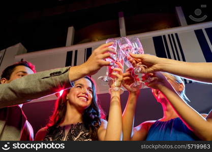 party, holidays, celebration, nightlife and people concept - smiling friends with glasses of champagne in club