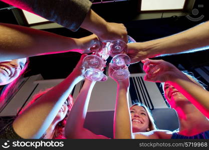 party, holidays, celebration, nightlife and people concept - smiling friends with glasses of champagne in club