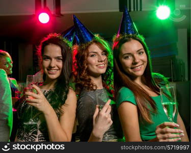 party, holidays, celebration, nightlife and people concept - smiling friends with glasses of champagne in club