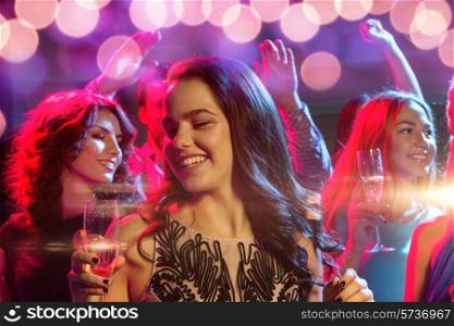 party, holidays, celebration, nightlife and people concept - smiling friends with glasses of champagne in club