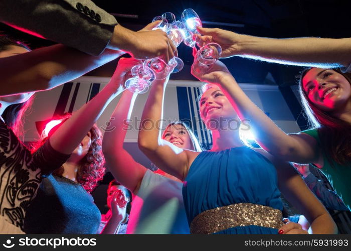 party, holidays, celebration, nightlife and people concept - smiling friends with glasses of champagne in club