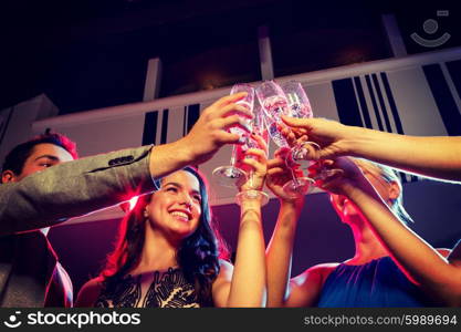 party, holidays, celebration, nightlife and people concept - smiling friends with glasses of champagne in club