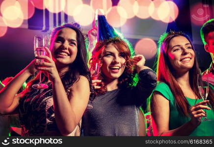 party, holidays, celebration, nightlife and people concept - smiling friends with glasses of champagne in club