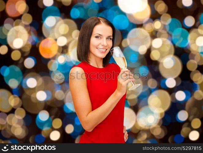 party, holidays, christmas and celebration concept - smiling woman with glass of non-alcoholic sparkling wine over lights background. smiling woman holding glass of sparkling wine