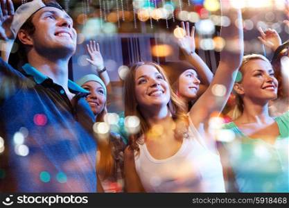 party, holidays, music events, nightlife and people concept - group of happy friends at hip-hop concert in night club