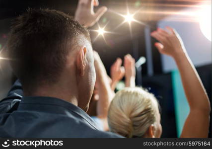 party, holidays, music, nightlife and people concept - close up of happy people at concert in night club waving hands