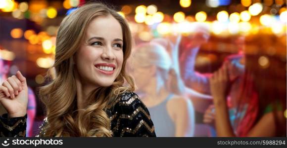 party, holidays, nightlife and people concept - face of happy young woman dancing over night club disco lights background