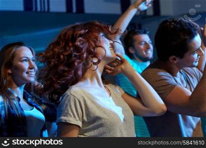 party, holidays, nightlife and people concept - happy friends dancing at night club