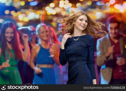 party, holidays, nightlife and people concept - happy young redhead woman dancing at night club disco over night lights background