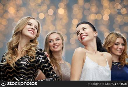 party, holidays, nightlife and people concept - happy young women dancing at party or disco over lights background