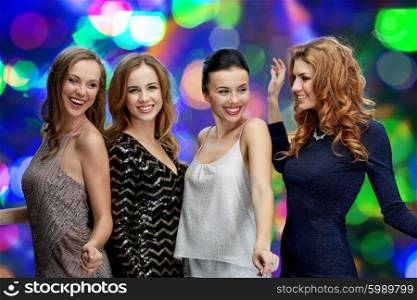 party, holidays, nightlife and people concept - happy young women dancing at night club disco over lights background