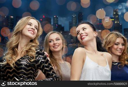 party, holidays, nightlife and people concept - happy young women dancing at night club disco over city and lights background