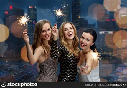 party, holidays, nightlife and people concept - happy young women dancing at night club disco over black background