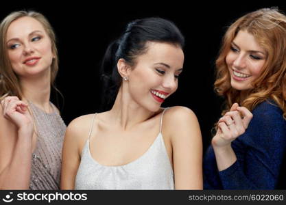 party, holidays, nightlife and people concept - happy young women dancing at night club disco over black background