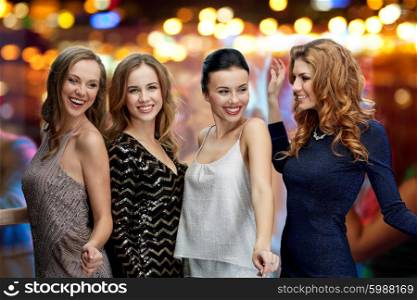 party, holidays, nightlife and people concept - happy young women dancing over night club disco lights background