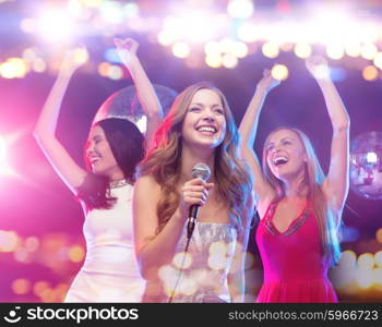 party, holidays, nightlife, entertainment and people concept - concept - happy women with microphone singing karaoke and dancing at night club