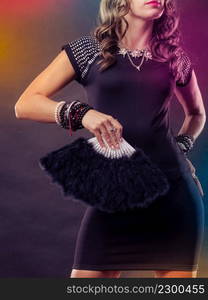 Party new year celebration and carnival concept. Beauty woman wearing evening dress with black feather fan in hand