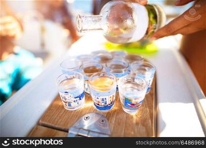 Party on the beach, refill glass with alcoholic beverage, drinking shots with friends, enjoying freedom, happy carefree summer vacation. Party on the beach