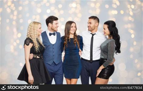 party, people and holidays concept - happy friends hugging over festive lights background. happy friends in party clothes hugging over lights. happy friends in party clothes hugging over lights