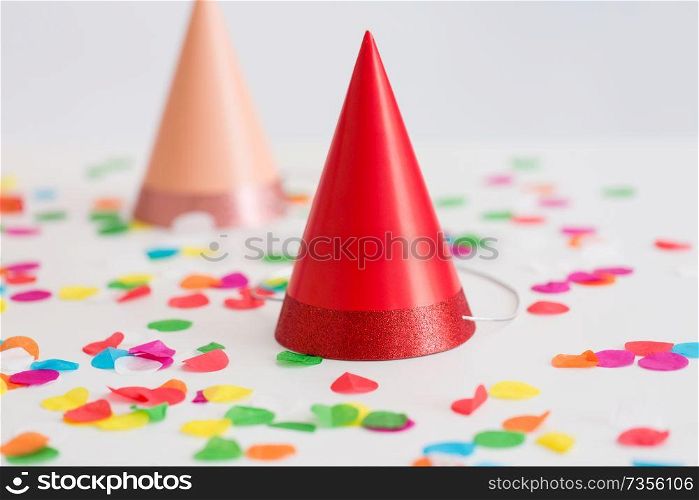 party props, accessory and festive concept - red birthday cap and confetti. red birthday party cap and confetti