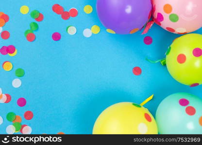 party props, celebration and decoration concept - colorful balloons and confetti on blue background. party balloons and confetti on blue background