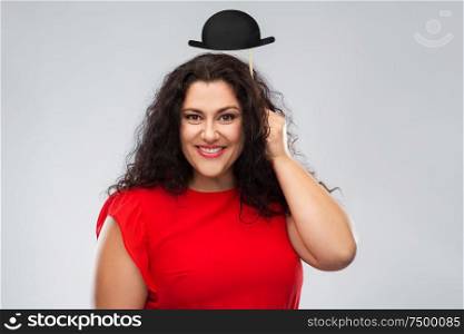 party props, photo booth and people concept - happy woman in red dress with black bowler hat over grey background. happy woman in red dress with black bowler hat