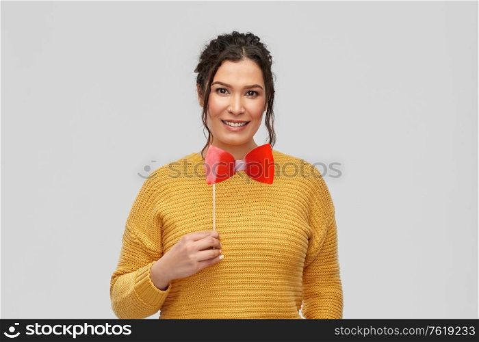 party props, photo booth and people concept - portrait of happy smiling young woman with pierced nose big red bowtie over grey background. happy young woman with big red bowtie party prop