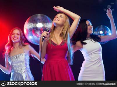 party, &quot;new year&quot;, celebration, friends, bachelorette party, birthday concept - three women in evening dresses dancing and singing karaoke