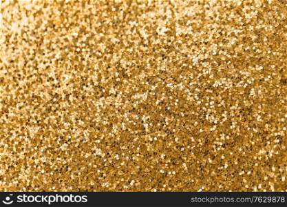 party, texture and holidays concept - golden glitters background. golden glitters background