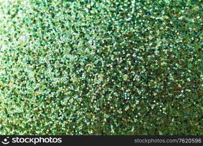 party, texture and holidays concept - green glitters or sequins background. green glitters or sequins background