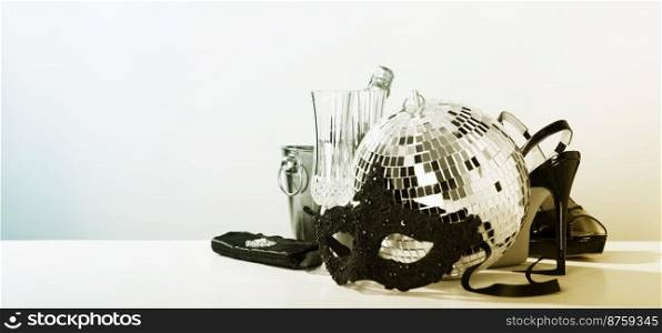 Party time concept. Christmas, New year&rsquo;s eve, Carnival, masquerade. Mask, champagne, party shoes and disco ball, copy space