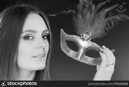 Party time, holidays, people and celebration concept. Woman long hair holding carnival mask close up. Black   white photo. Woman holding carnival mask closeup